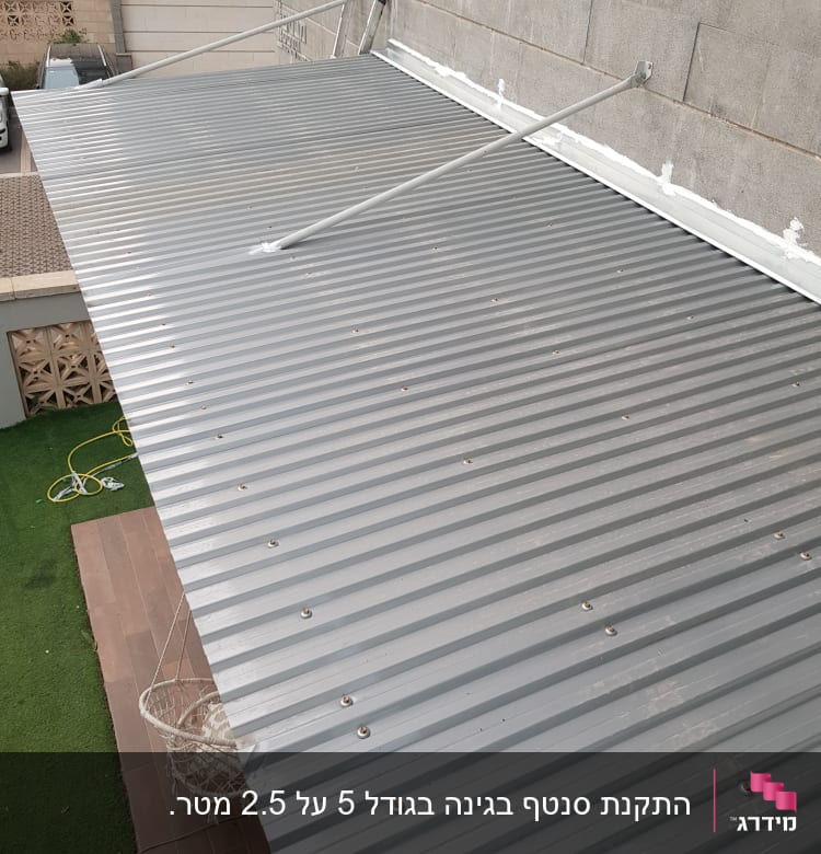 גג מתכת מחובר לקיר עם מוטות תמיכה